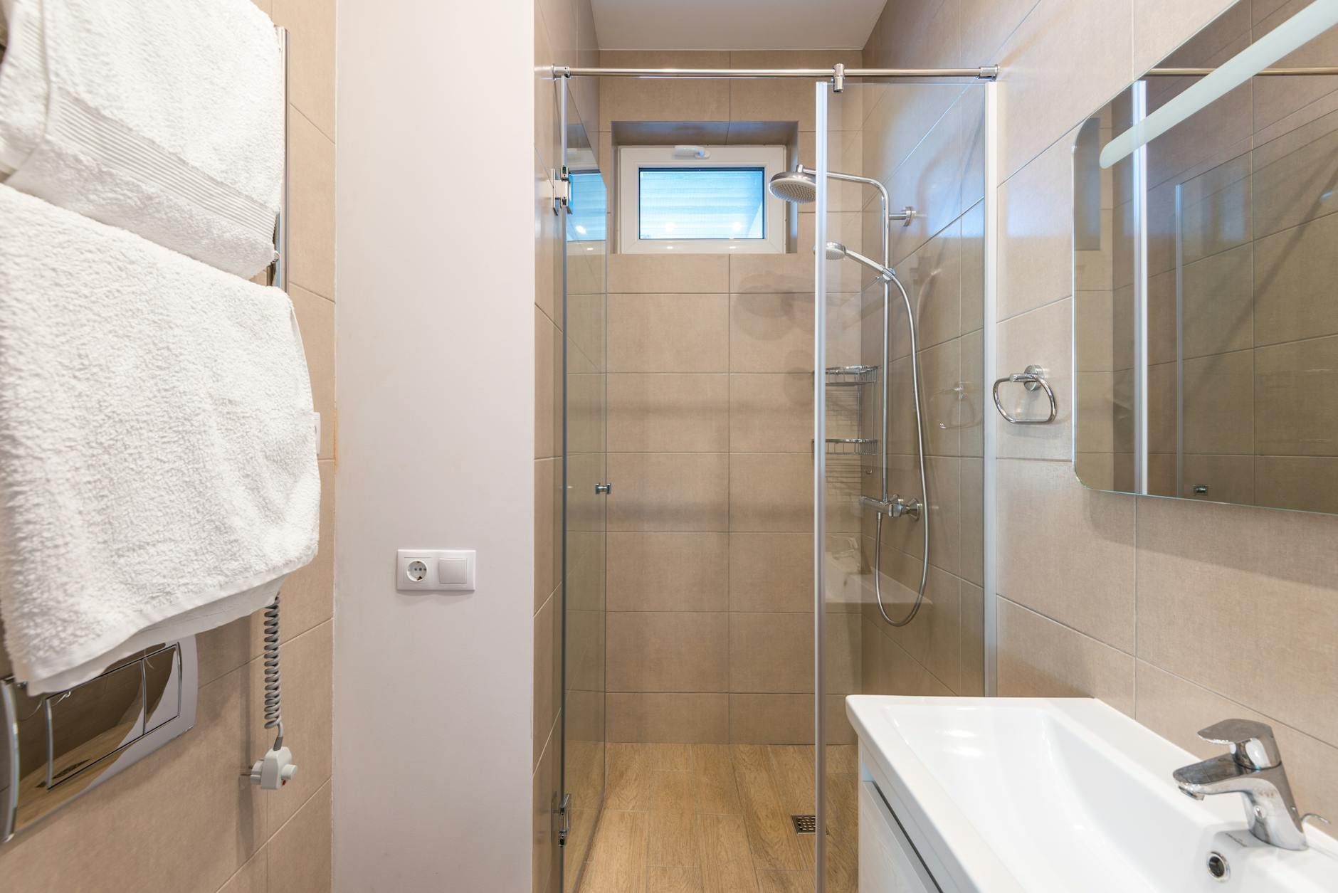 Nowoczesna łazienka z prysznicem w szklanej niszy i beżowymi płytkami