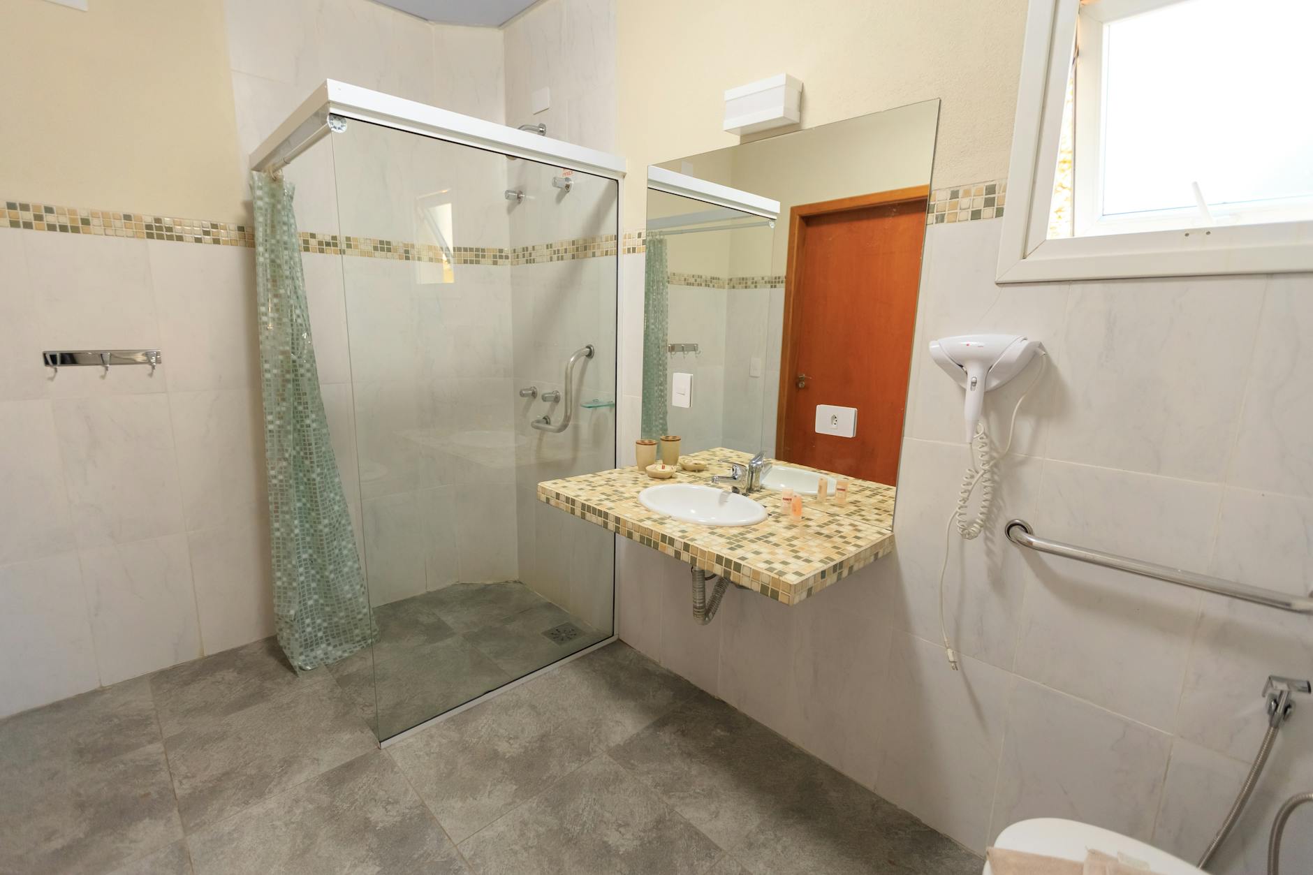 Przestronna bezbarierowa łazienka z prysznicem walk‑in i nowoczesną umywalką